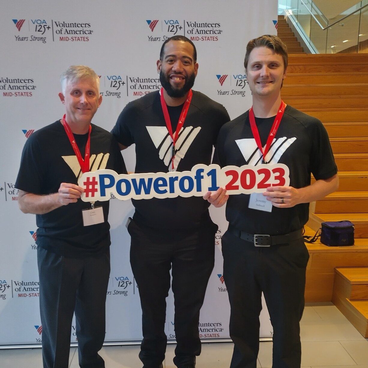 3 men holding a power of 1 2023 sign